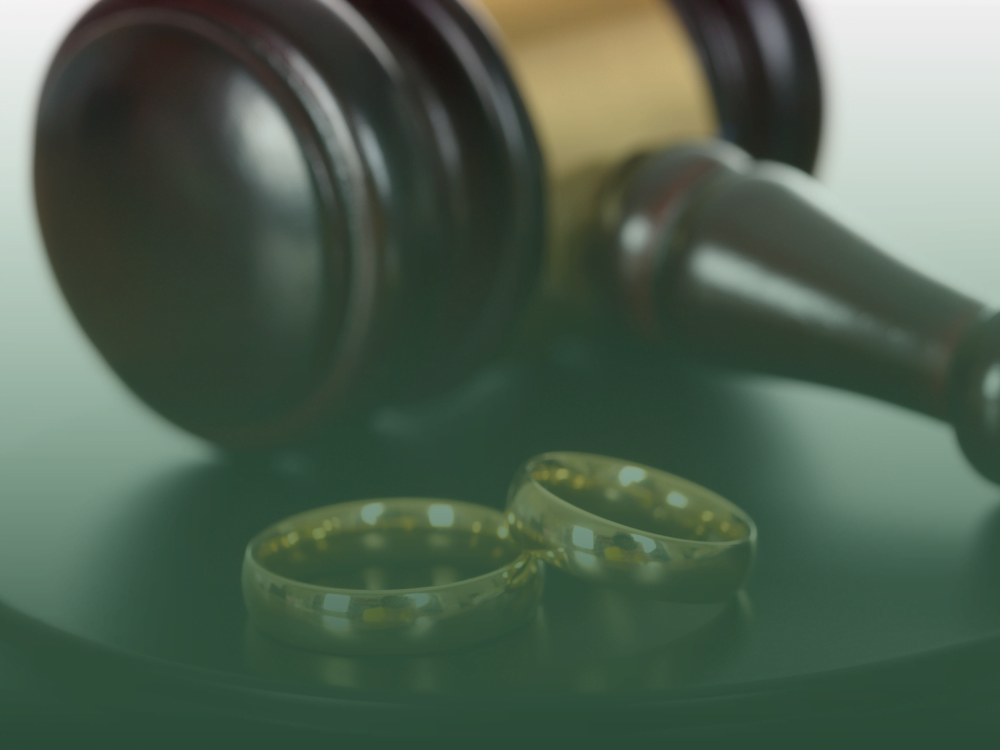 Wedding rings and a gavel representing marriage law in Thailand.