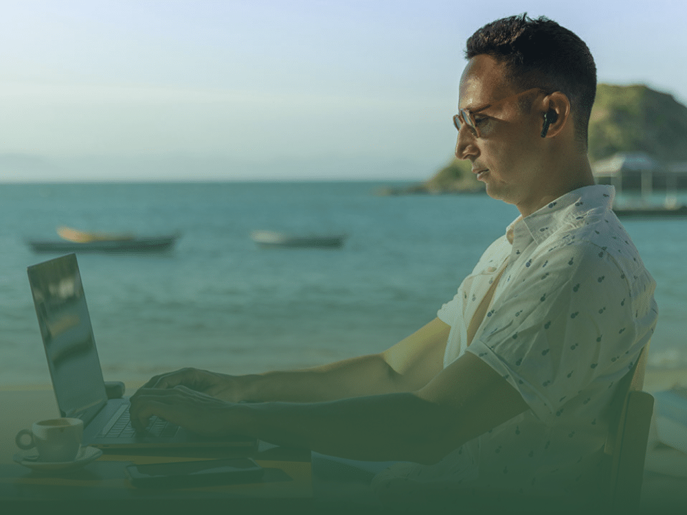 Man working on a laptop by the beach in Phuket, exemplifying the digital nomad lifestyle.